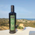 Quaranta Gusto Olivenöl-Flasche auf Sardinien; daneben grüne Oliven und Pane Carasau, im Hintergrund die Costa Smeralda.